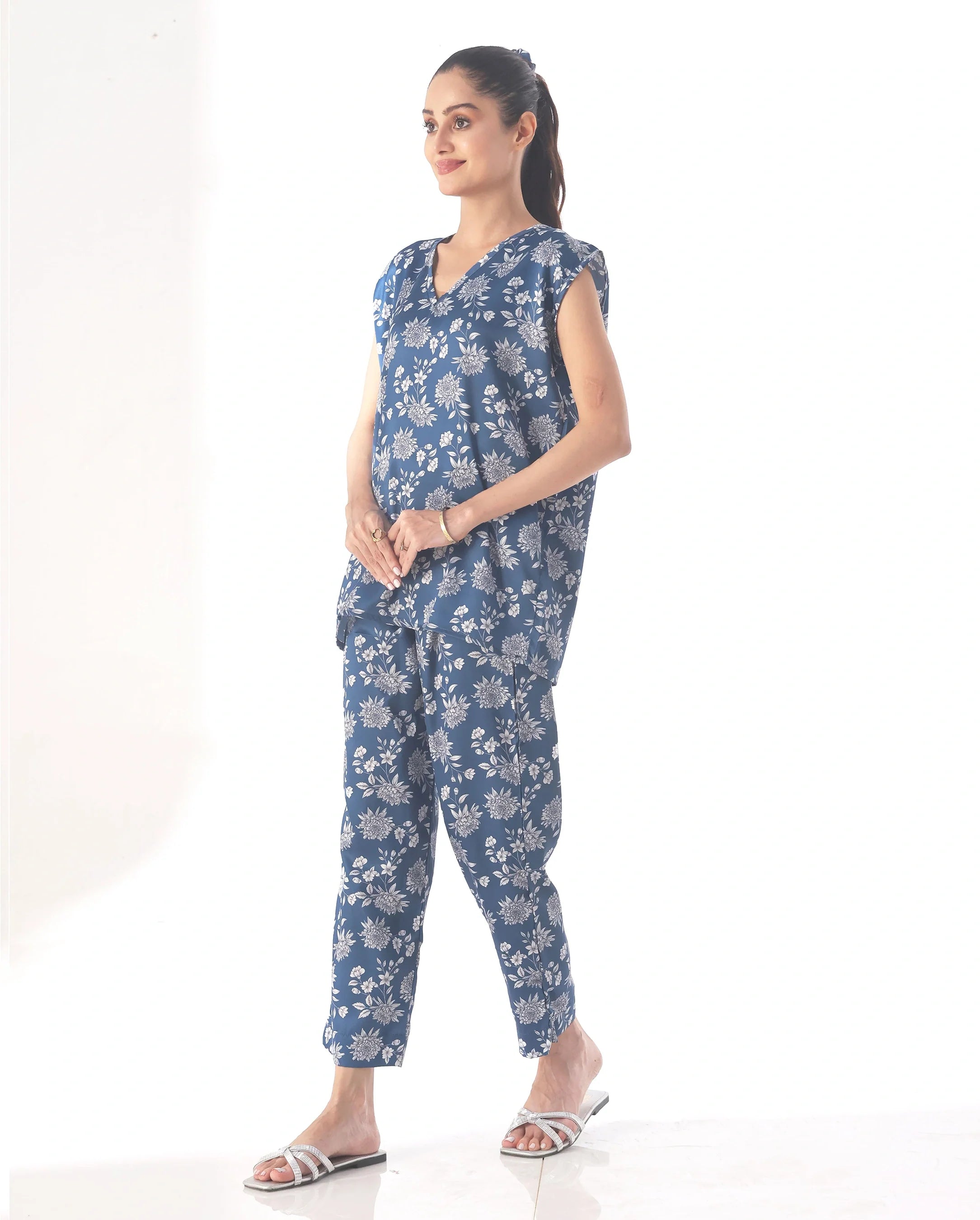 Woman wearing a blue floral jumpsuit on a white background
