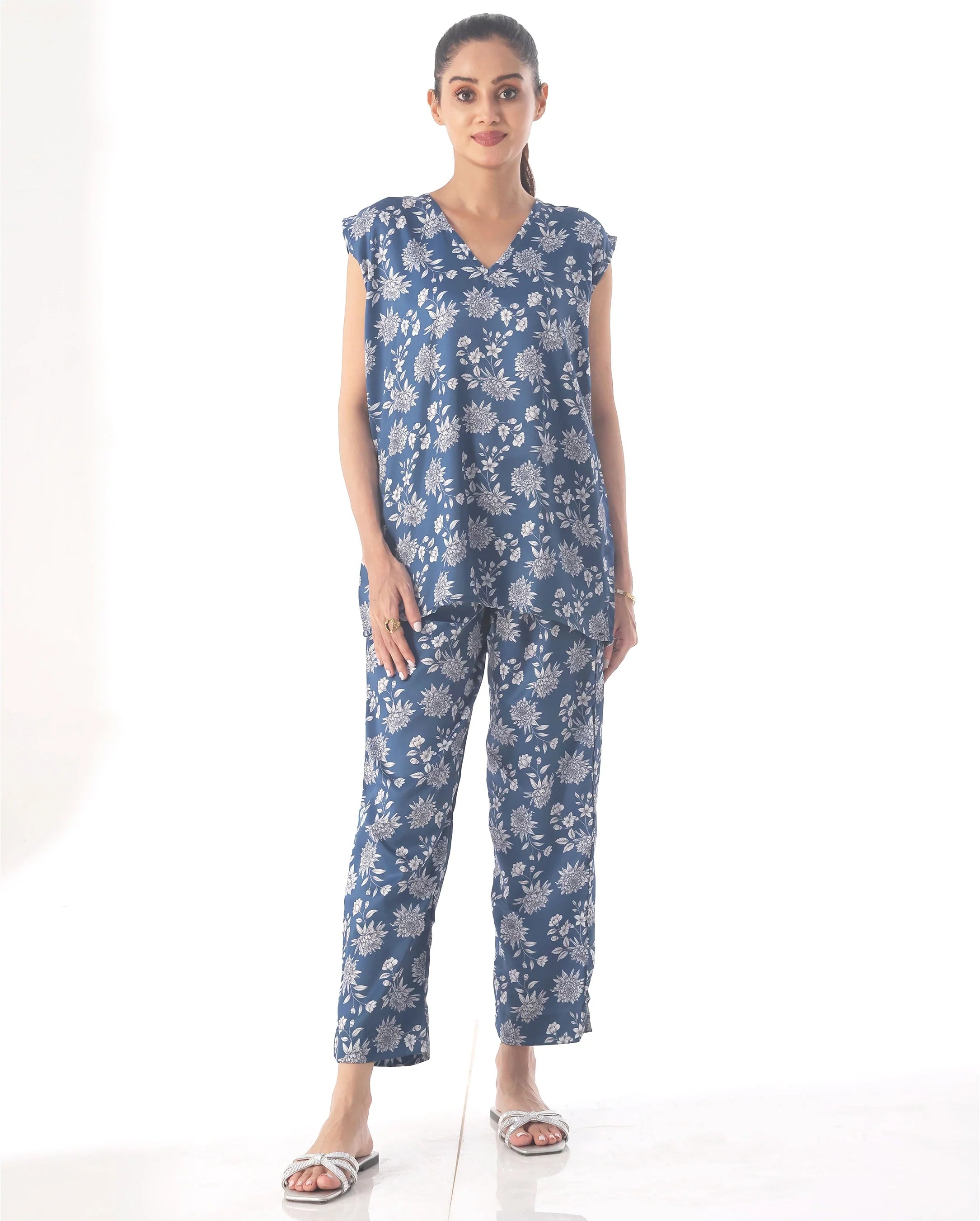 Woman wearing a blue floral jumpsuit on a white background